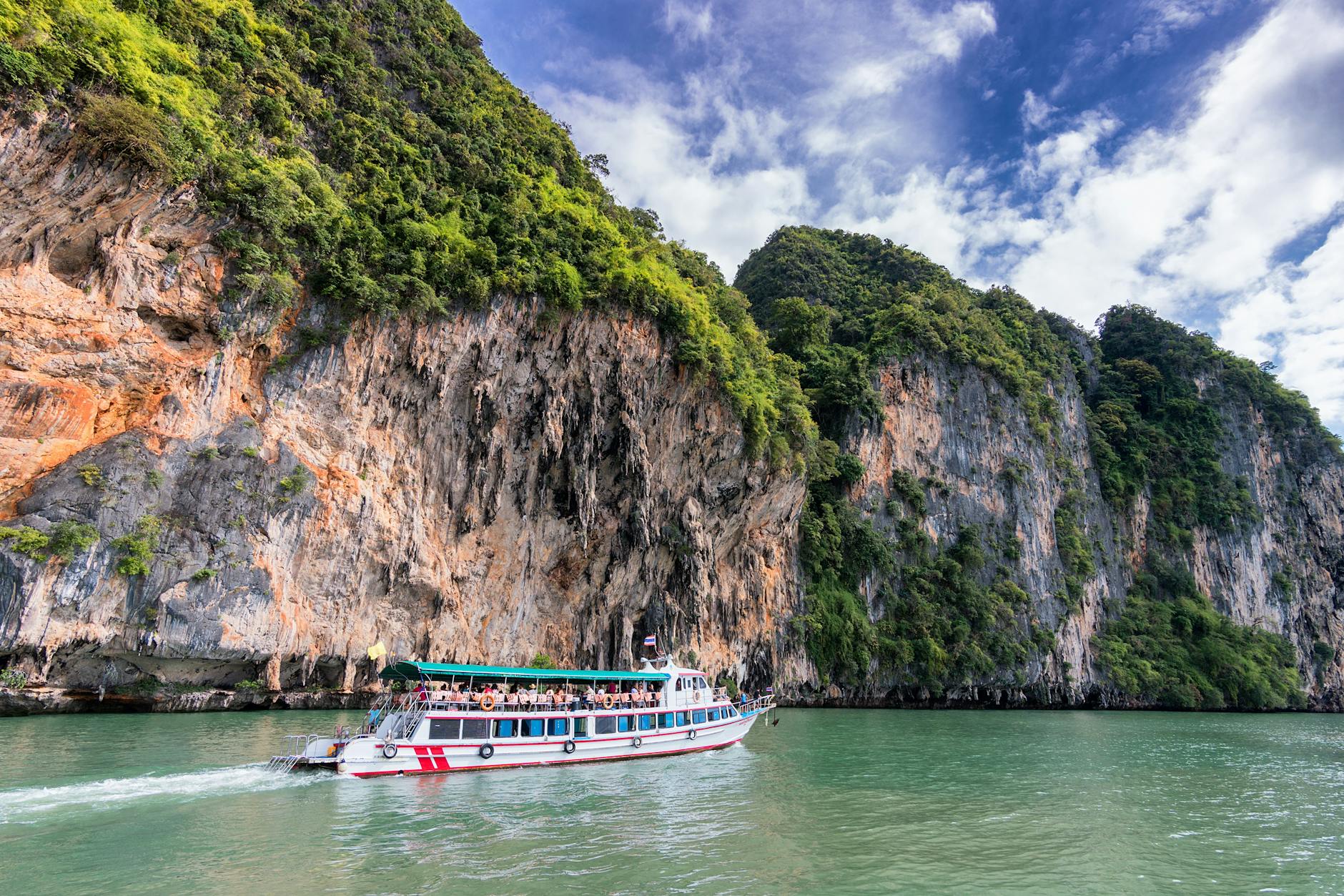 people on ship traveling on water beside land